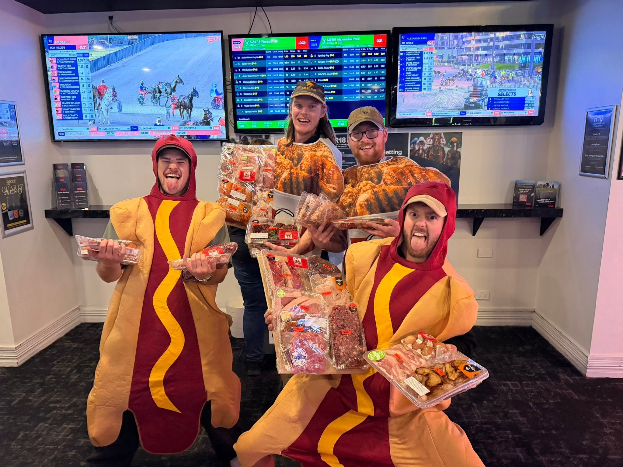 Four patrons in novelty costumes with meat raffle prizes